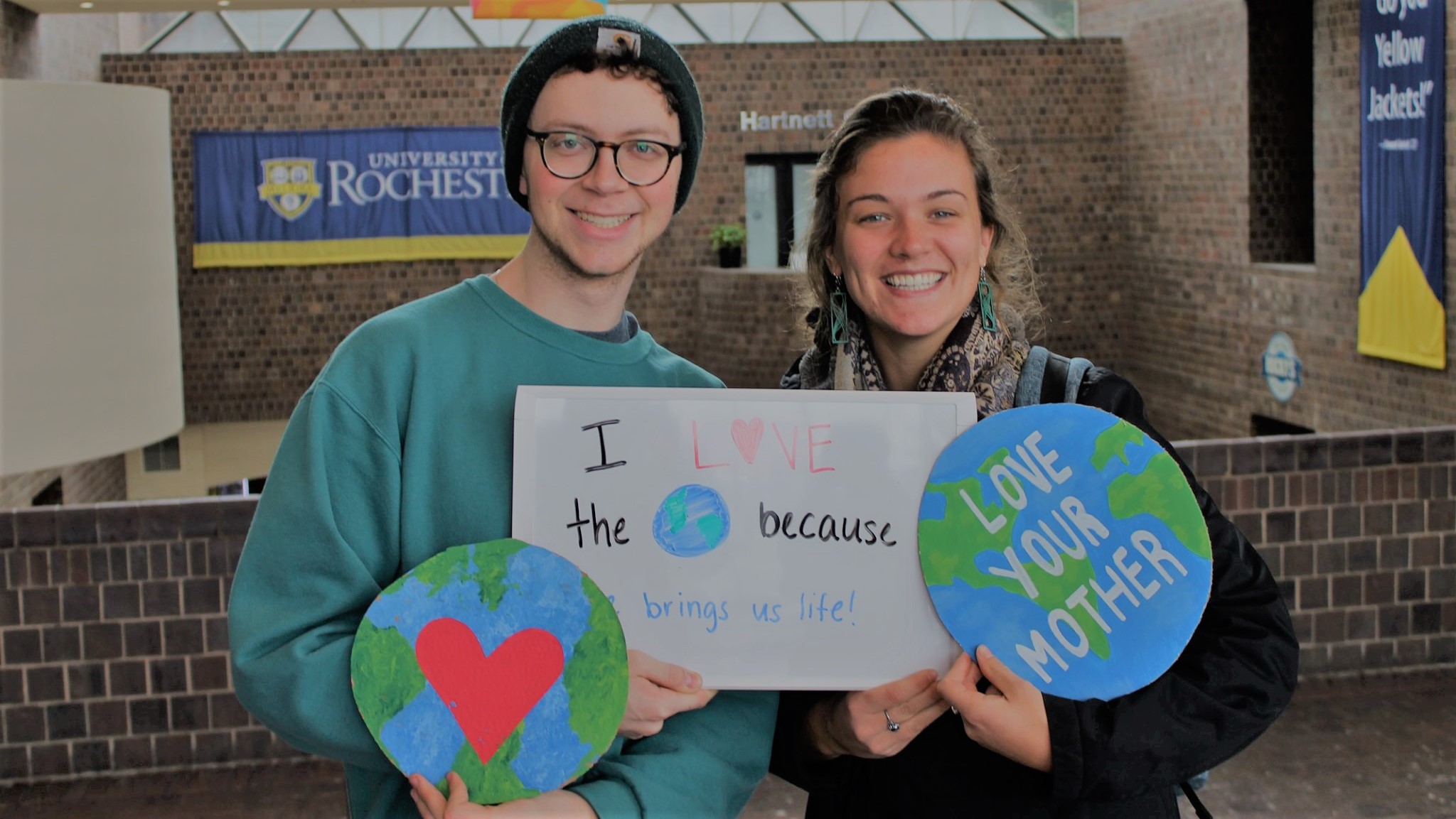 two people holding signs that say love your mother earth