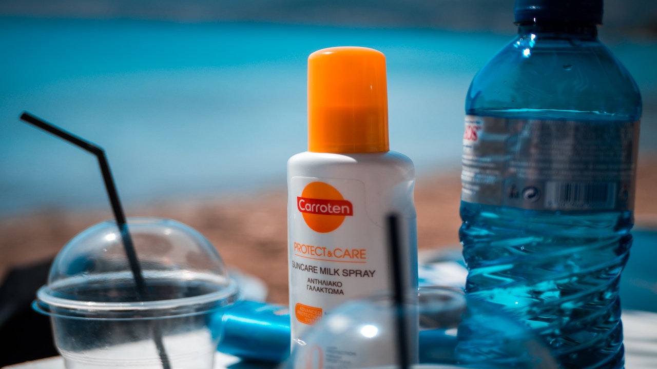This picture shows bottles of sunscreen outside on a beach.