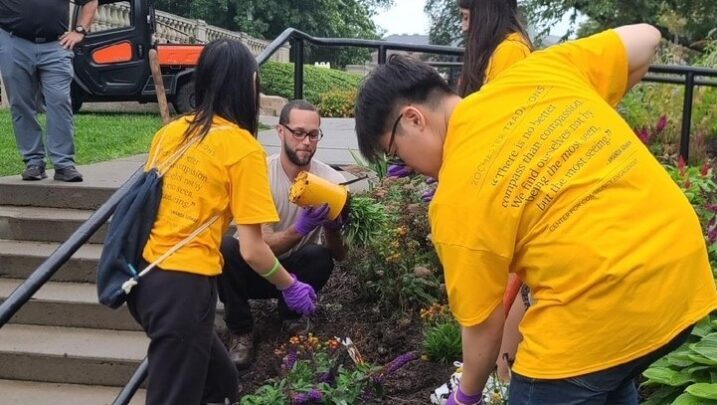 students work with Grounds staff to plant flowers on campus for pollinators