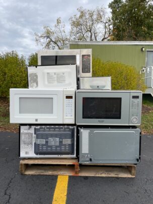 image of microwaves stacked on top of each other for recycling.