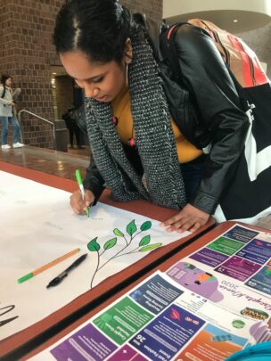 woman signing sustainability expression wall