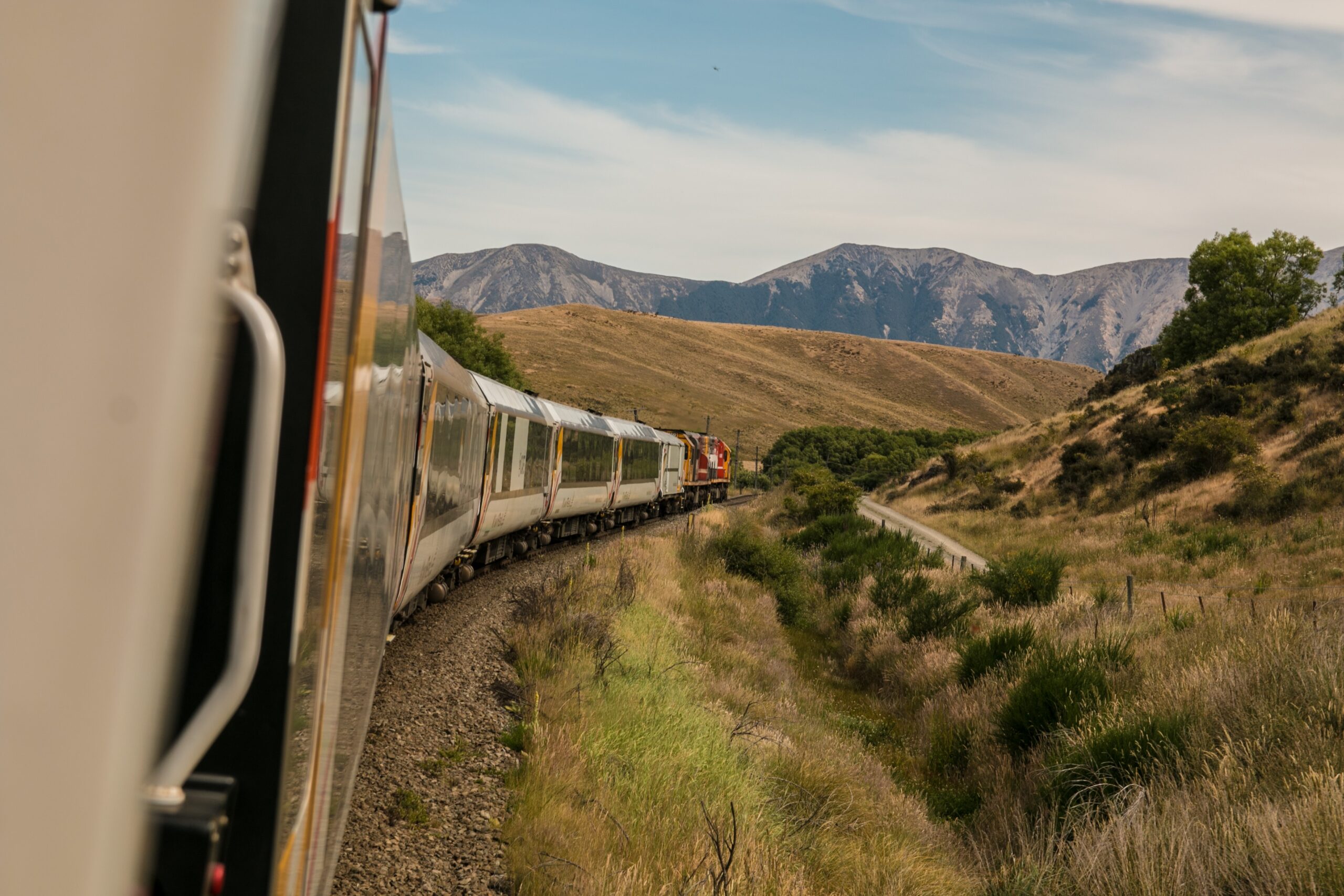 A train journeys through a brown mountainous area.